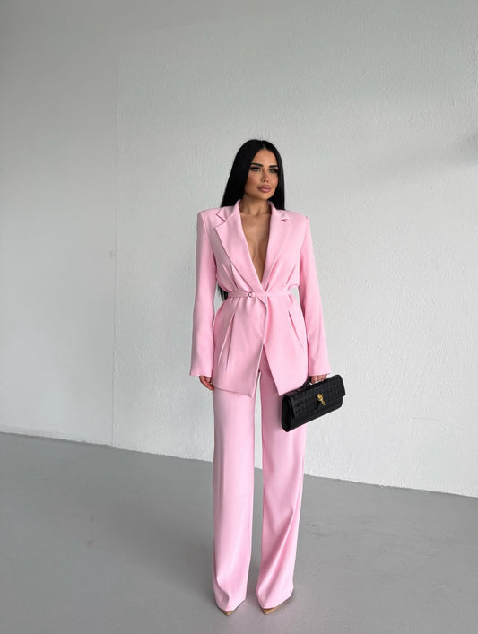 Tailleur Samira dal taglio sofisticato composto da blazer con cintura che valorizza il punto vita e pantaloni palazzo dalla linea fluida. Elegante, femminile e moderno, è il look perfetto per distinguersi con stile in eventi, serate o occasi