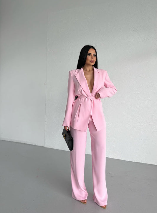 Tailleur Samira dal taglio sofisticato composto da blazer con cintura che valorizza il punto vita e pantaloni palazzo dalla linea fluida. Elegante, femminile e moderno, è il look perfetto per distinguersi con stile in eventi, serate o occasi